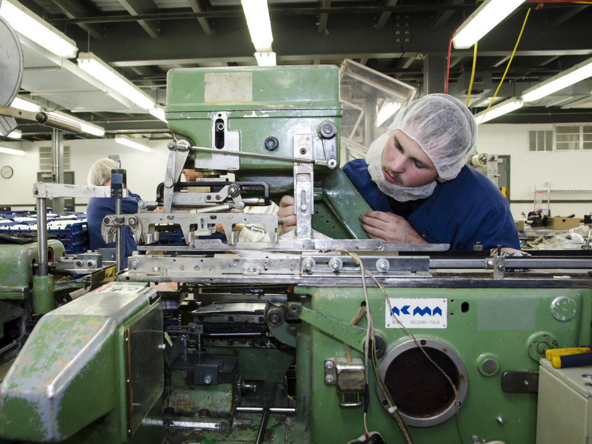 Man in hair net working on machine