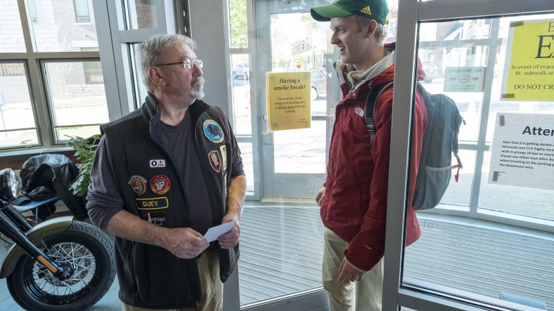 veteran greets student in doorway