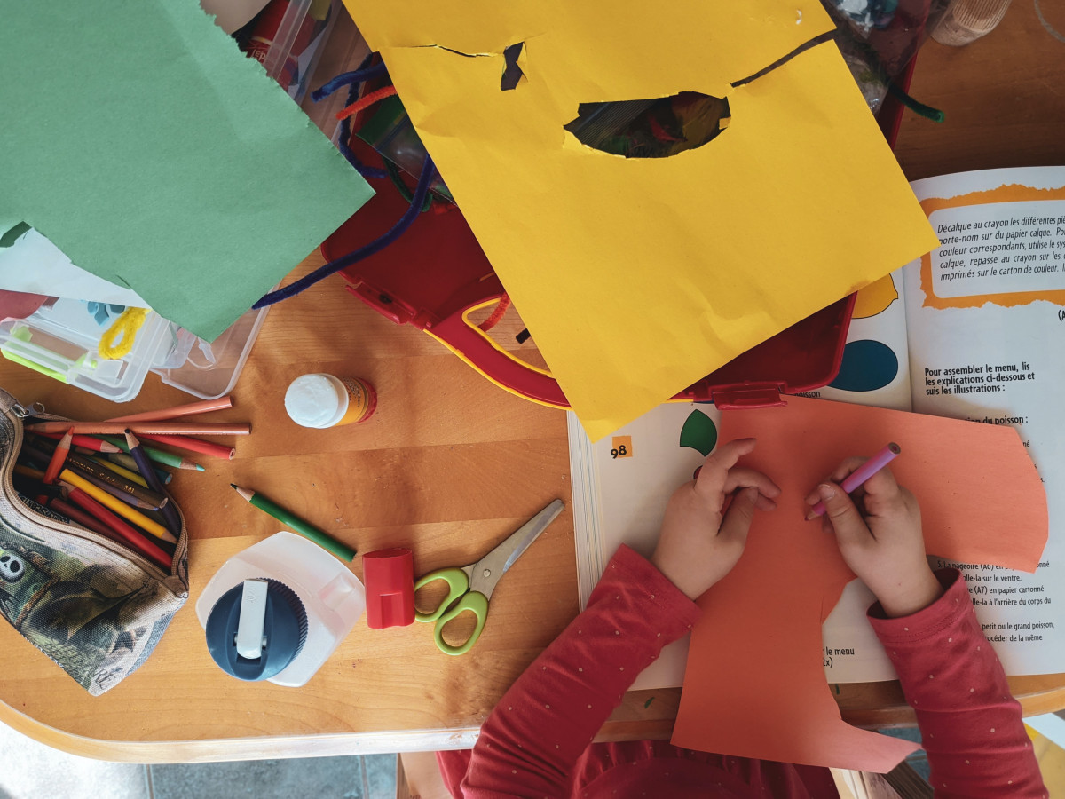 child's hands with construction paper and scissors