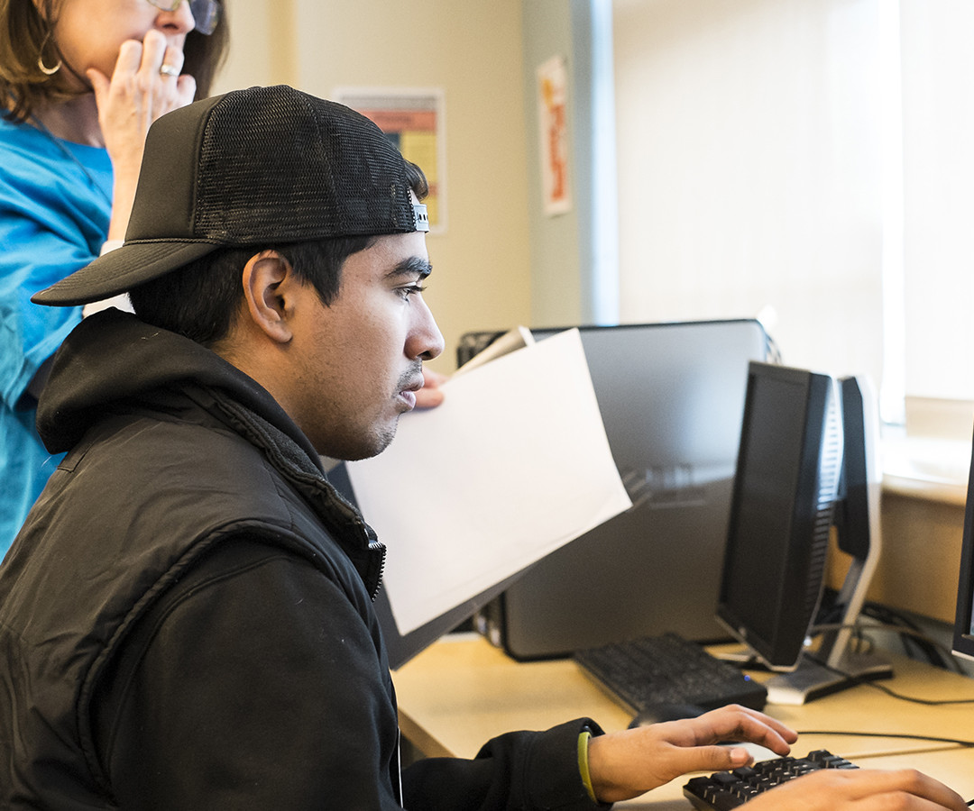 Student at computer with instructor